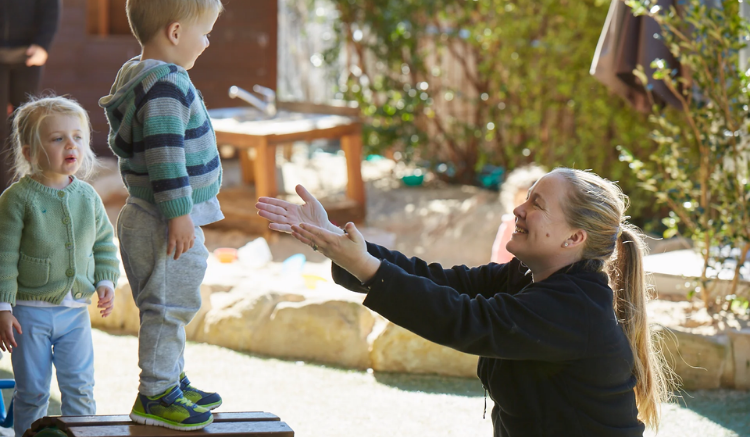 blonde woman reaching out her arms to hold little blonde boy